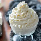 Coppa di golosa crema di latte, decorata con una sac à poche, pronta per essere gustata.