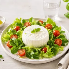 Insalata fresca con un disco di primo sale, pomodorini e basilico, condita con olio d'oliva.