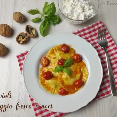 Ravioli ripieni di formaggio fresco e noci, conditi con pomodorini e basilico. Una deliziosa ricetta da provare!