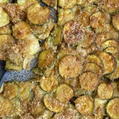 Fette di zucchine al forno, dorate e croccanti, con pangrattato e parmigiano. Un contorno saporito e facile da preparare.