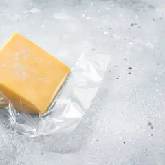 Un pezzo di formaggio giallo, sottovuoto, pronto per essere conservato. Quanto dura il formaggio sottovuoto?