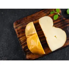 Scamorza affumicata su tagliere di legno, perfetta per una mamma in gravidanza che cerca un sapore autentico e sicuro.