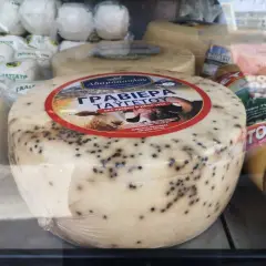 Formaggio rotondo con puntini neri, forse pepe, etichetta con pecora. Non è feta, ma una graviera greca.