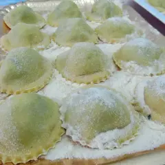 Ravioli verdi su vassoio, perfetti con cosa sostituire la ricotta nella dieta.