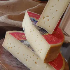 Fette di formaggio stagionato, con buchi, su un tagliere. Attenzione, la scamorza fa ingrassare!