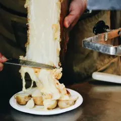 Formaggio per raclette alternativa, fuso e filante, viene raschiato da un grosso pezzo su patate bollite.