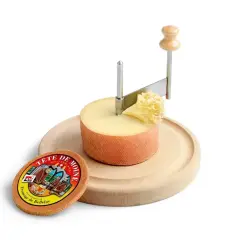 Forme di formaggio Tête de Moine su tagliere di legno, con girolle per creare riccioli.