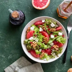 Insalata con pompelmo, noci e formaggi magri quali sono, condita con miele e aceto balsamico.