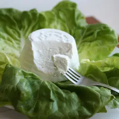 Ricotta fresca su foglie di lattuga, un'opzione leggera per chi cerca poche calorie.