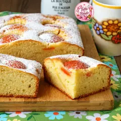 Torta albicocche e yogurt soffice, cosparsa di zucchero a velo, con pezzi di albicocca visibili. Perfetta per la colazione.
