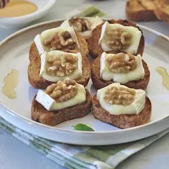 Deliziosi crostini con formaggio fuso e noci, un antipasto perfetto per ogni occasione.