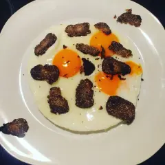 Uova al tartufo e formaggio, un piatto semplice ma raffinato. Le uova sono cotte alla perfezione, con tuorli morbidi e albumi bianchi e sodi. Il tartufo nero, tagliato a lamelle sottili, aggiunge un aroma intenso e un sapore inconfondibile. Il formaggi...