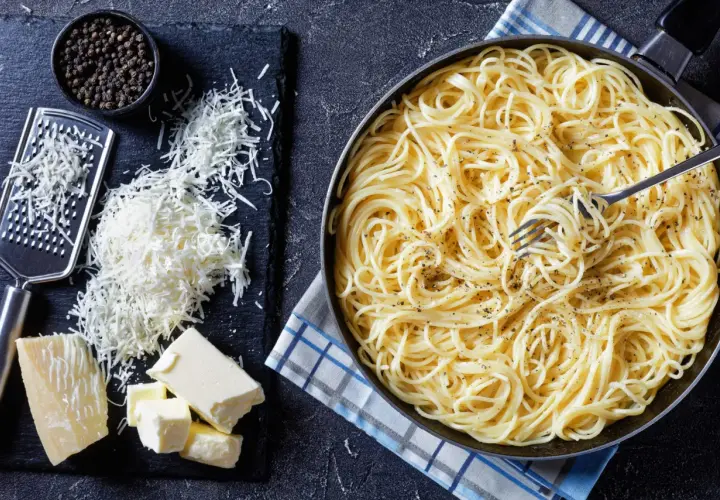 Spaghetti conditi con burro e pepe, pronti per essere arricchiti con pecorino, fonte di proteine.