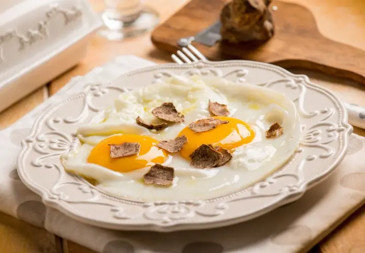 Uova al tegamino con scaglie di tartufo nero, un'idea per ricette semplici e raffinate.