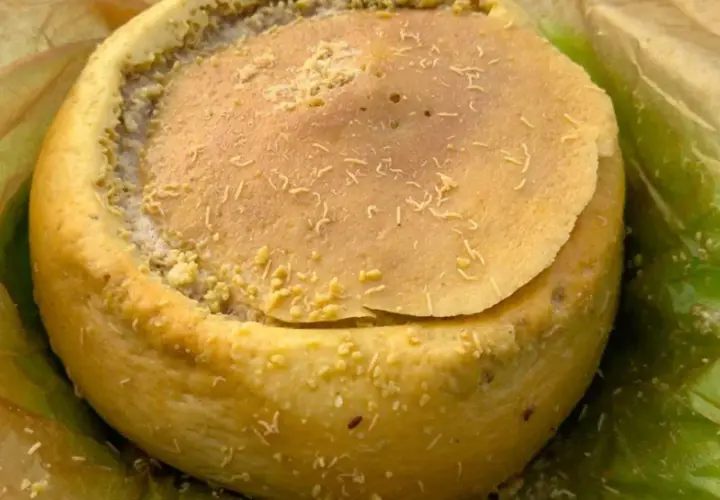 Formaggio casu marzu, con la sua crosta dorata e il ripieno cremoso, pronto per essere gustato.