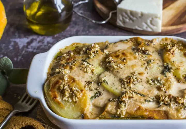 Piatto di patate e formaggio filante, un delizioso pecorino al forno con noci croccanti e erbe aromatiche.