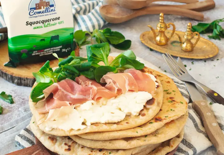 Piadina con squacquerone, prosciutto crudo e insalatina. Un classico degli abbinamenti perfetti per un pasto veloce e gustoso.