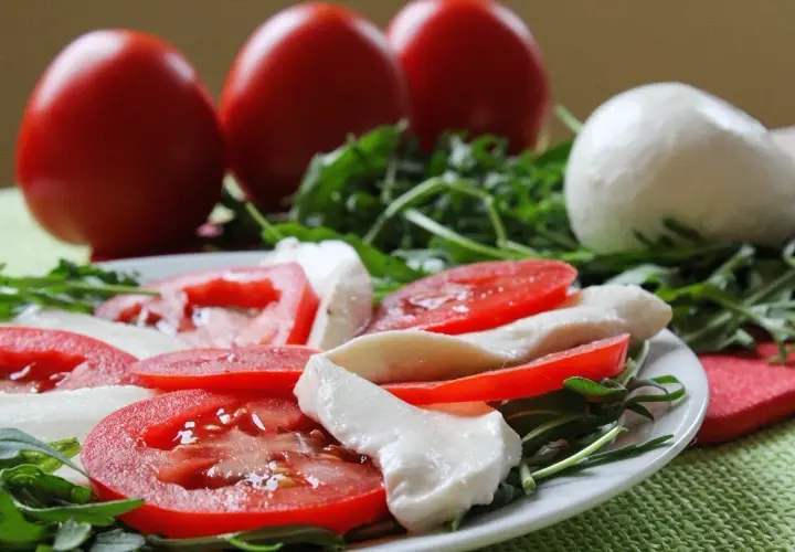 Caprese con burrata, pomodori freschi e rucola. Un piatto leggero e gustoso, perfetto per chi cerca un'alimentazione sana, anche in gravidanza.