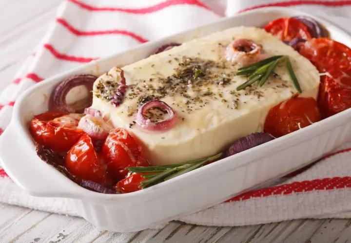 Piatto da forno con formaggio feta greca, pomodorini, cipolla rossa e rosmarino.