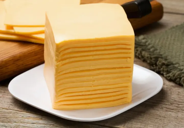Una pila di sottilette su un piatto bianco, perfette per uno spuntino in gravidanza.