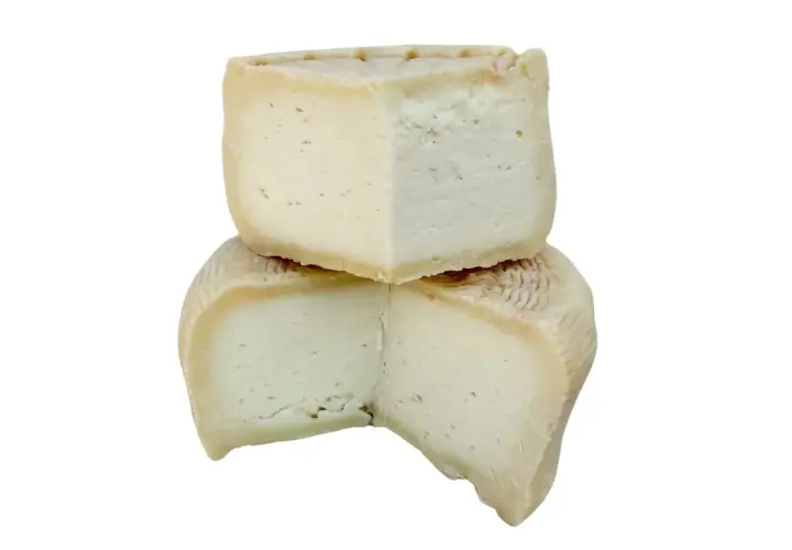 Due fette di formaggio, una sopra l'altra, con una crosta rigata. Quale preferisci: meglio formaggio di capra o pecora?