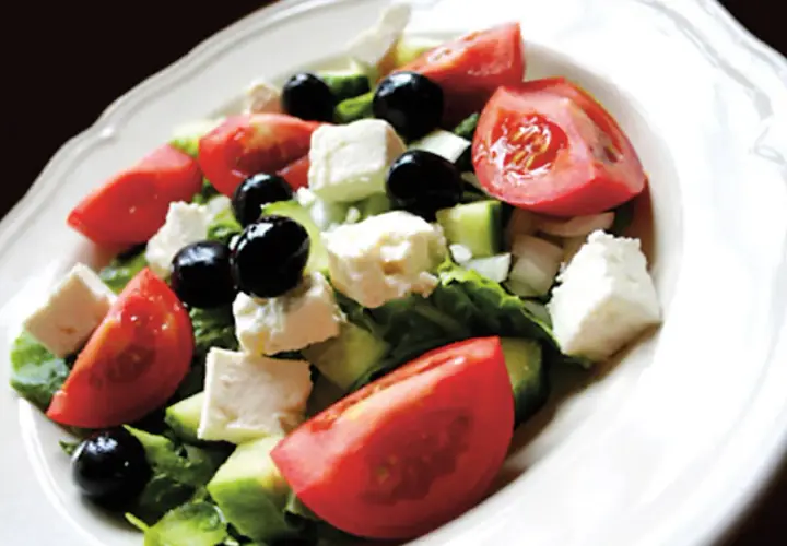 Insalata greca con pomodori, cetrioli, olive nere e cubetti di formaggio feta.