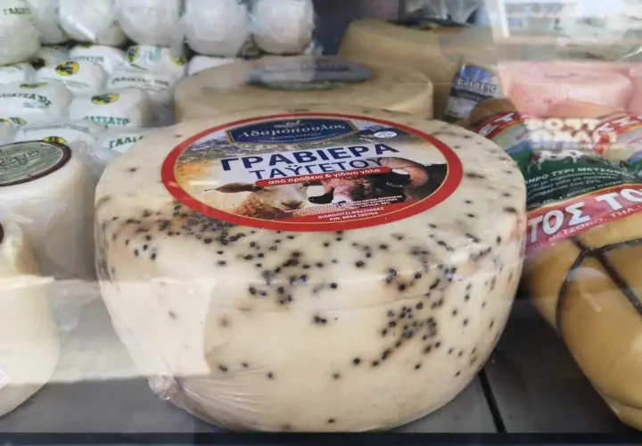 Formaggio rotondo con puntini neri, forse pepe, etichetta con pecora. Non è feta, ma una graviera greca.