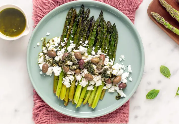 Asparagi grigliati con feta sbriciolata, olive e salsa verde. Un modo gustoso per condire la feta e creare un piatto fresco e saporito.