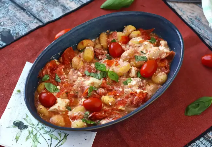 Gnocchi al forno con pomodorini e formaggio cremoso, un'ottima alternativa per chi cerca come sostituire la feta in una ricetta mediterranea.