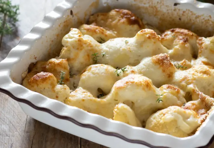 Cavolfiore al forno con pangrattato e formaggio filante, guarnito con rametti di timo fresco.