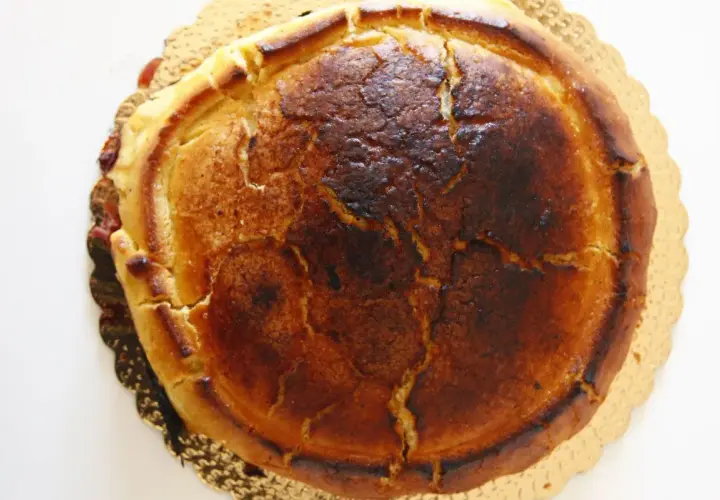 Crostata ricotta e visciole dorata, con la crosta leggermente bruciacchiata e un ripieno invitante.