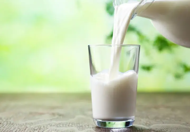 Versando latte fresco in un bicchiere, un'opzione salutare per chi cerca latte che non fa ingrassare.