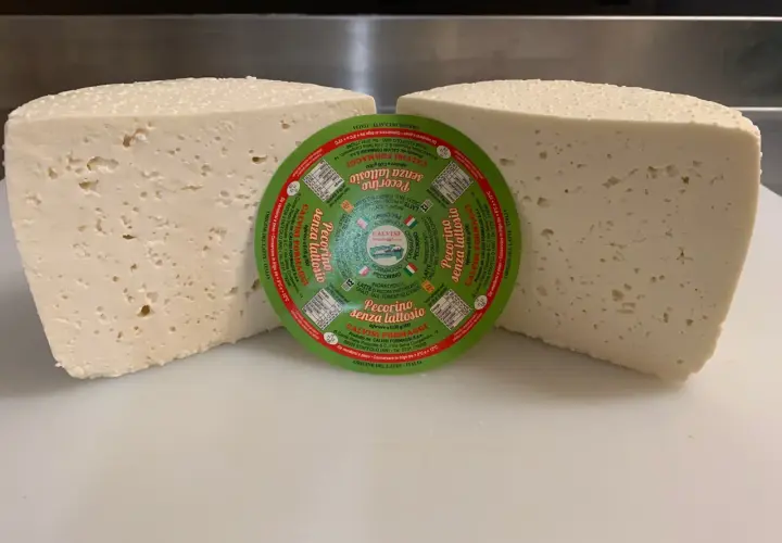 Due forme di pecorino senza lattosio, una con etichetta circolare verde al centro.