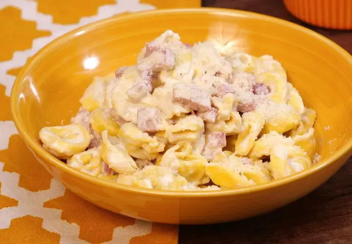 Tortellini panna e prosciutto, un piatto cremoso e saporito, servito in una ciotola gialla.