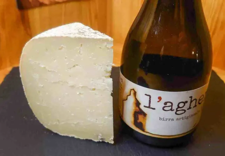 Un pezzo di formaggio stagionato accanto a una bottiglia di birra artigianale. Attenzione, il tomino fa ingrassare!