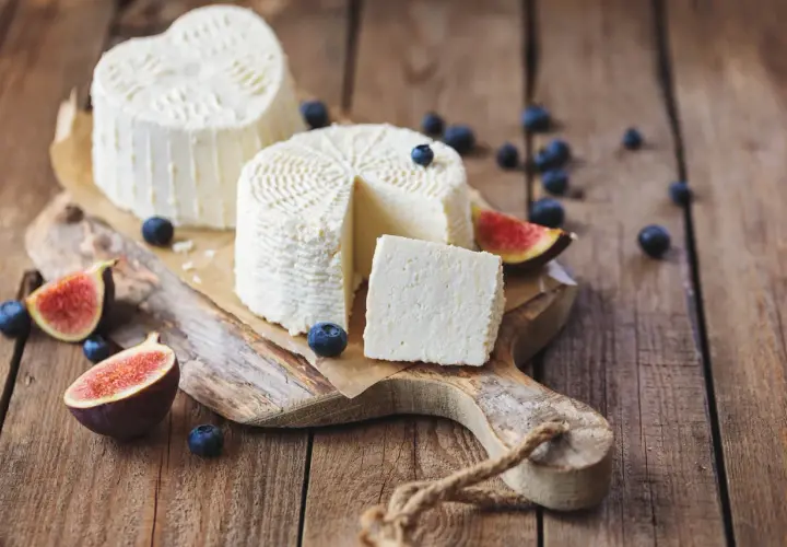Ricotta fresca, a cuore e rotonda, con mirtilli e fichi. Un formaggio leggero, con pochi grassi saturi, perfetto per una colazione sana.