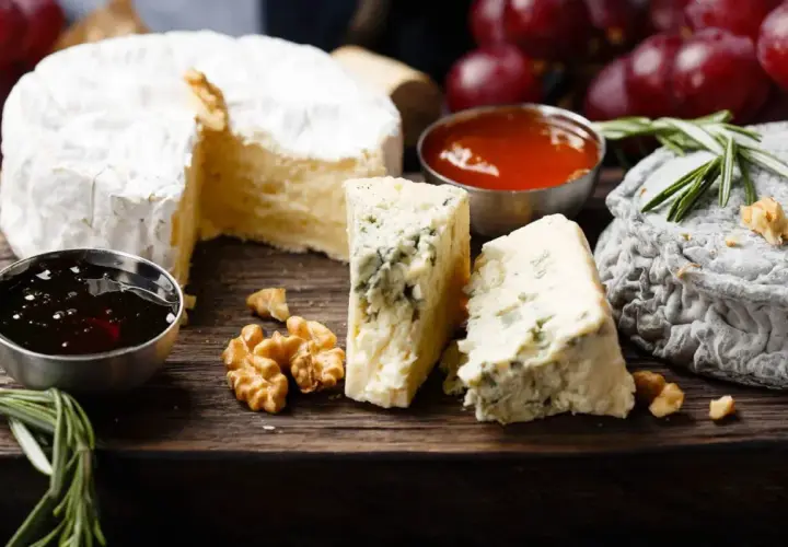Assaggio di formaggi: un cremoso, un erborinato con venature blu e un formaggio grigio. Accompagnati da noci, miele e uva rossa.