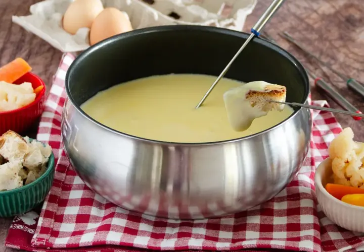 Una calda fonduta Valle d'Aosta, con pane croccante e verdure fresche, pronta per essere gustata.