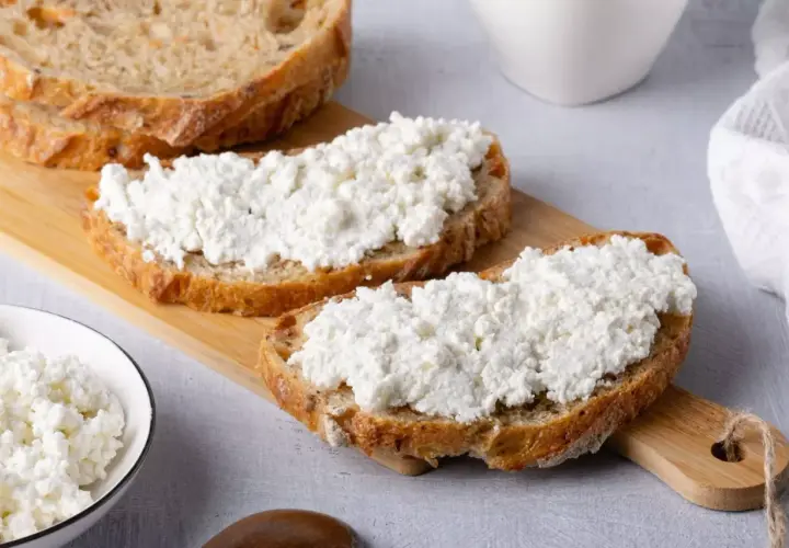 Fette di pane rustico con ricotta fresca, un'ottima scelta per scoprire i benefici della ricotta.