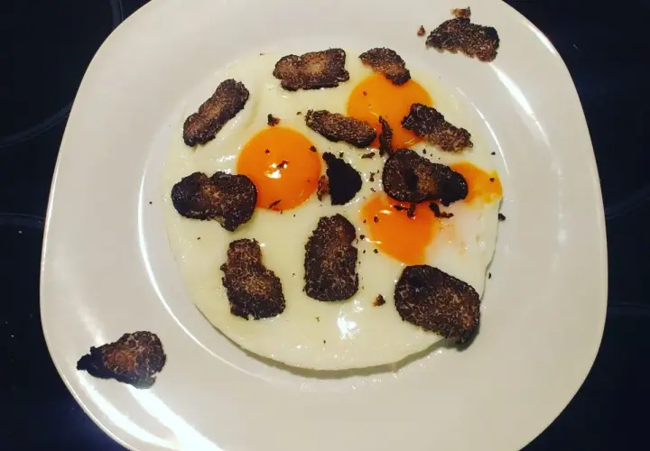 Uova al tartufo e formaggio, un piatto semplice ma raffinato. Le uova sono cotte alla perfezione, con tuorli morbidi e albumi bianchi e sodi. Il tartufo nero, tagliato a lamelle sottili, aggiunge un aroma intenso e un sapore inconfondibile. Il formaggi...