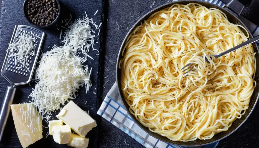 Spaghetti conditi con burro e pepe, pronti per essere arricchiti con pecorino, fonte di proteine.