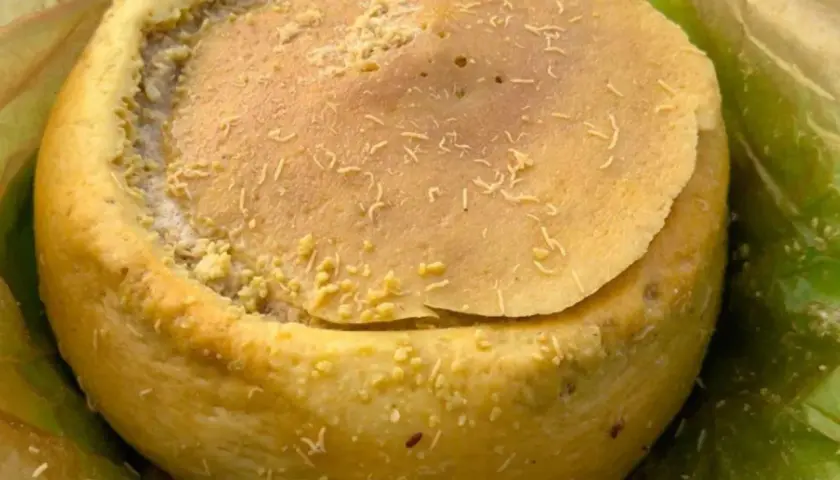 Formaggio casu marzu, con la sua crosta dorata e il ripieno cremoso, pronto per essere gustato.