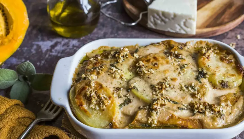 Piatto di patate e formaggio filante, un delizioso pecorino al forno con noci croccanti e erbe aromatiche.