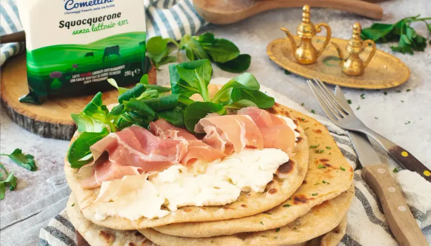 Piadina con squacquerone, prosciutto crudo e insalatina. Un classico degli abbinamenti perfetti per un pasto veloce e gustoso.