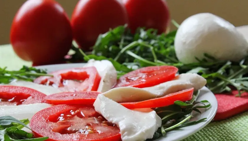 Caprese con burrata, pomodori freschi e rucola. Un piatto leggero e gustoso, perfetto per chi cerca un'alimentazione sana, anche in gravidanza.