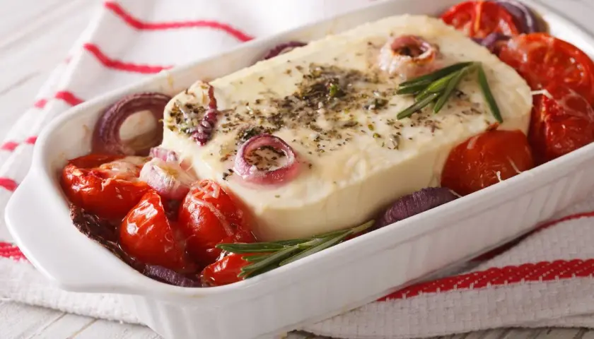 Piatto da forno con formaggio feta greca, pomodorini, cipolla rossa e rosmarino.