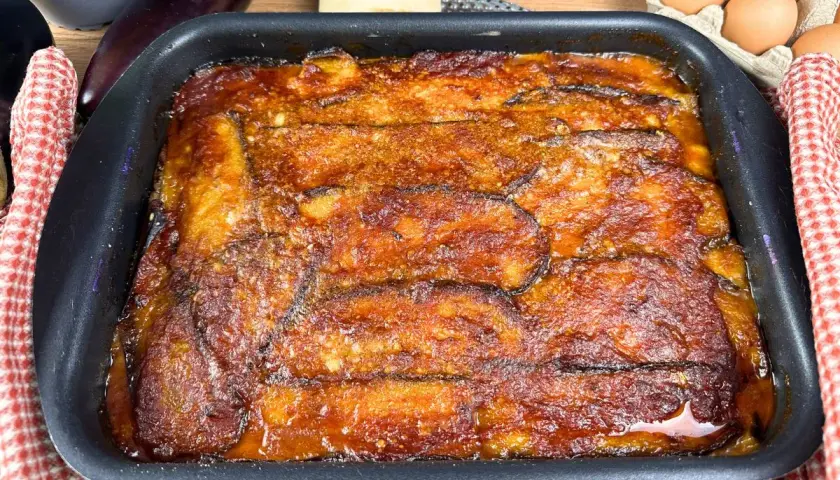 Parmigiana di melanzane non fritte appena sfornata, dorata e invitante, pronta per essere gustata.
