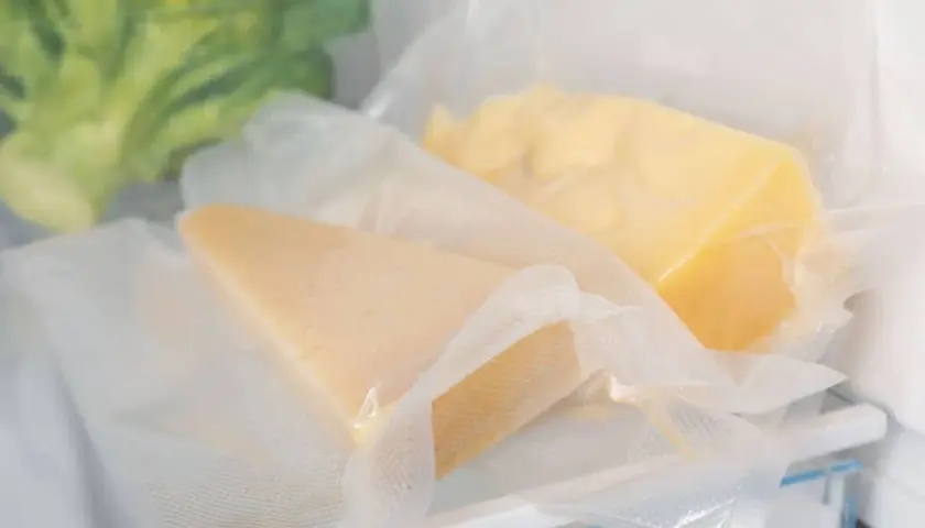 Due pezzi di formaggio stagionato sottovuoto, un metodo efficace per capire come conservare il formaggio in frigo.