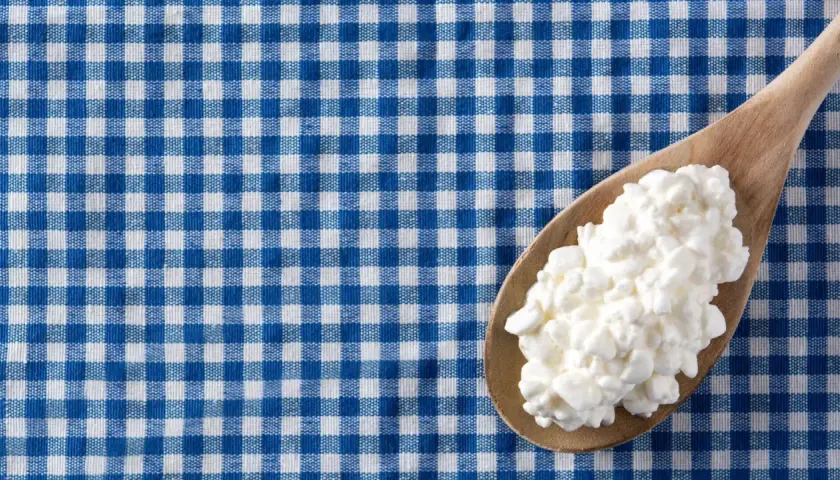 Un cucchiaio di jocca in gravidanza su una tovaglia a quadri blu e bianchi.