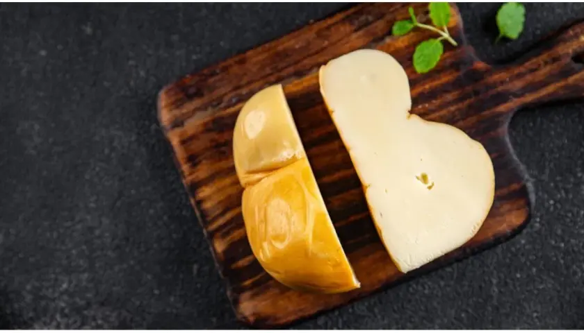 Scamorza affumicata su tagliere di legno, perfetta per una mamma in gravidanza che cerca un sapore autentico e sicuro.